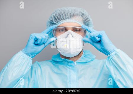 Gros plan photo de Guy expert doc centre de virologie clinique tenir les bras sur les lunettes de protection porter des gants masque bleu noismat uniforme costume plastique visage Banque D'Images