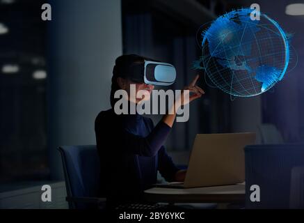 Femme d'affaires avec lunettes de réalité virtuelle touchant le globe virtuel Banque D'Images