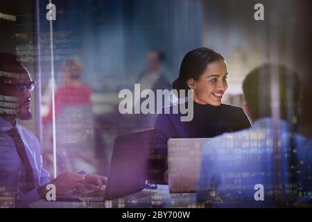 Femme d'affaires souriante à l'ordinateur portable lors d'une réunion dans un bureau en hauteur Banque D'Images