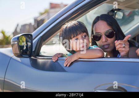 Mère et fils qui regardent la fenêtre de voiture ensoleillée Banque D'Images