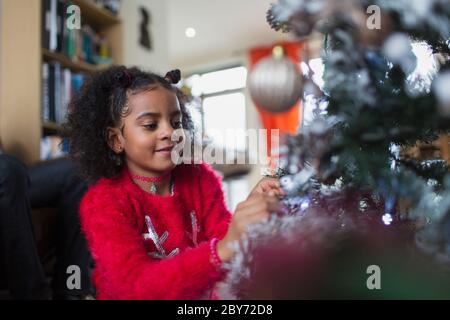 Girl decorating Christmas Tree Banque D'Images
