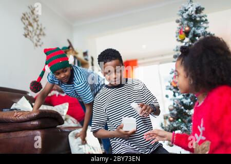 L'ouverture de la famille cadeau de Noël dans la salle de séjour Banque D'Images