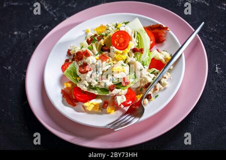 salade iceberg au fromage bleu, bacon croustillant, tomates cerises, œufs durs, ciboulette sur une table en béton, clo Banque D'Images