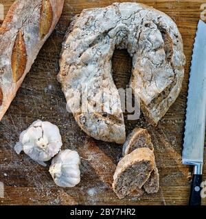 Pain rustique de noyer à l'ail sur une planche de bois Banque D'Images