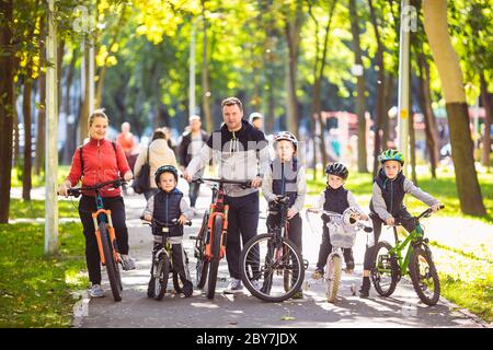 Thème famille sports actifs loisirs en plein air. Un groupe de personnes est une grande famille de 6 personnes se tenant debout sur des vélos de montagne dans un parc de la ville sur un Banque D'Images