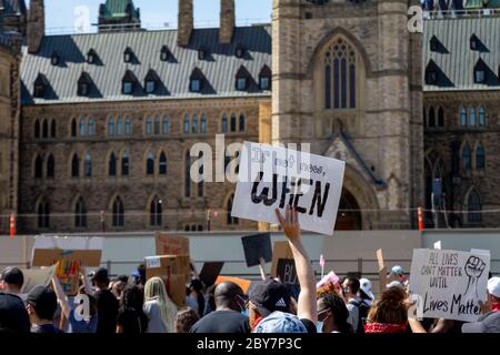 Un panneau de protestation portant la mention « si pas maintenant, quand » est tenu dans une foule de milliers sur la colline du Parlement à Ottawa, au Canada, pour protester contre la violence policière. Banque D'Images