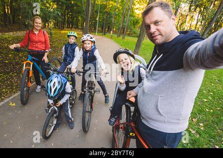 Le thème famille sports loisirs de plein air. grande famille 6 personnes de race blanche Papa maman et 4 enfants trois frères et soeur de la bicyclette dans le parc Banque D'Images