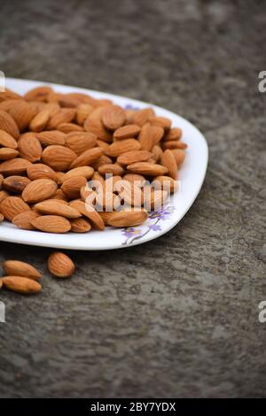 Amandes sur une assiette. Les amandes sont des noix saines et l'un des meilleurs aliments pour le cerveau. Banque D'Images