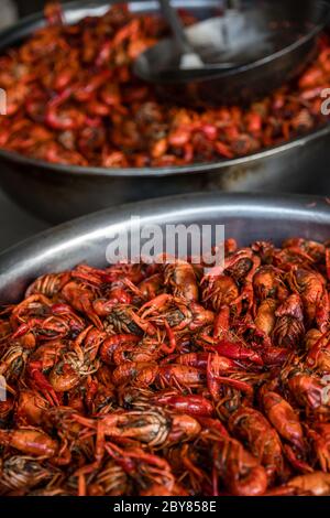 Crevettes épicées rouges cuites et frites servies dans une petite cuisine de rue à Feng Huang, en Chine Banque D'Images