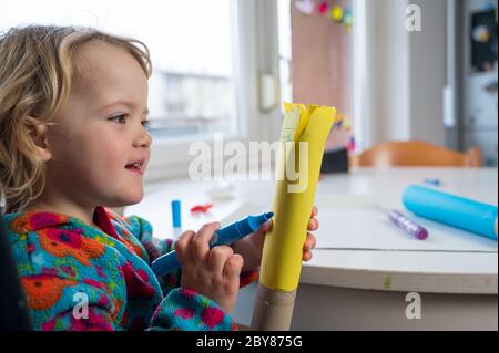 Jolie fille blonde paitining avec beaucoup de couleurs en utilisant le pinceau et les doigts. Banque D'Images