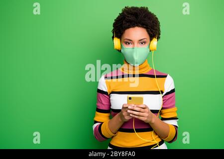 Portrait de belle fille belle et saine à cheveux ondulés portant un masque de sécurité équipement préventif à l'aide de l'appareil parcourir nouvelles arrêter pathogène cov ncov-2 soins de santé Banque D'Images