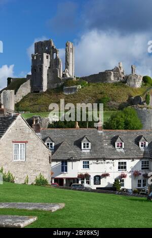 Le Greyhound Pub et les ruines du château, Corfe Castle, Dorset, Angleterre, Royaume-Uni Banque D'Images