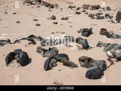 Gros plan sur les vieilles bottes militaires en décaissement abandonnées dans le désert africain éloigné Banque D'Images