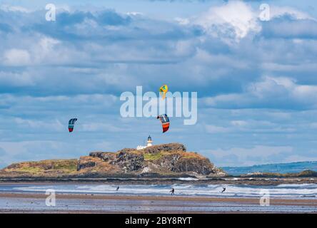 Kitesurfers ou boarders kite surfant dans un vent fort avec Fidra Island, Broadsands Bay, Firth of Forth, East Lothian, Écosse, Royaume-Uni Banque D'Images