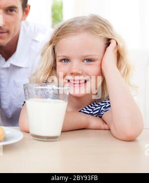 Smiling little girl drinking milk Banque D'Images