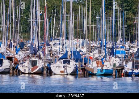 Beaucoup de petits bateaux à voile avec des mâts sans ancrage de gréement à un stade d'atterrissage dans le port du grand lac Banque D'Images