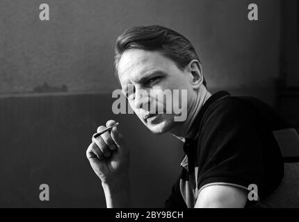 Un homme avec une cigarette. Contraste de lumière du soleil. Tabagisme et santé. Noir et blanc. Banque D'Images