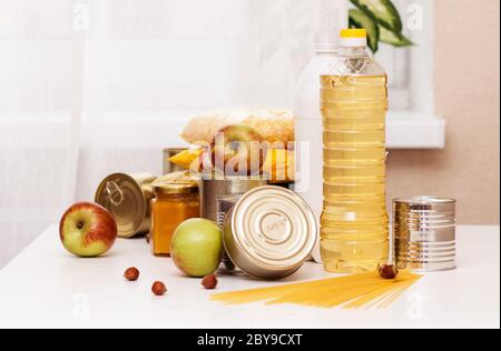 Divers produits en conserve, pâtes et céréales sur une table blanche. Concept de don ou de livraison de nourriture Banque D'Images