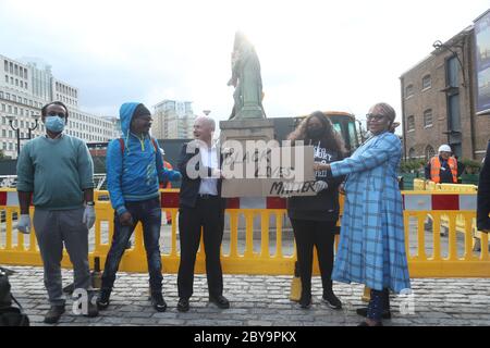 Les travailleurs se préparent à prendre une statue du propriétaire d'esclaves Robert Milligan sur West India Quay, à l'est de Londres, tandis que les conseils du travail d'Angleterre et du pays de Galles commenceront à examiner les monuments et les statues dans leurs villes et villages, Après une manifestation, des militants anti-racisme ont démolir une statue d'un commerçant d'esclaves à Bristol. Banque D'Images