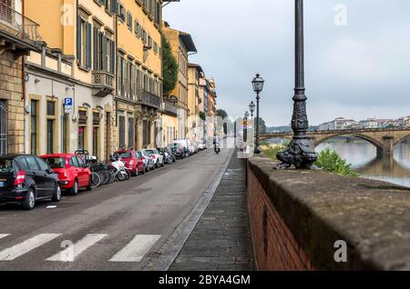 Riverside Street - UNE vue nuageux d'octobre matin sur une étroite rue à sens unique, le long de la rivière Arno, dans la vieille ville de Florence. Toscane, Italie. Banque D'Images