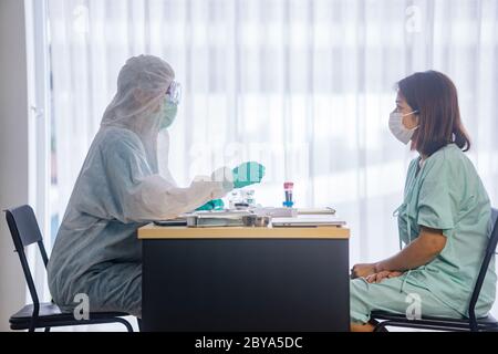 Femme asiatique patient être rassurée par une femme médecin dans la chambre d'hôpital Banque D'Images