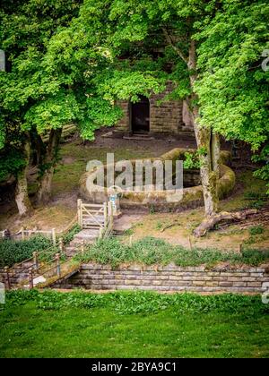 Bâtiment en pierre sur le bord du réservoir inférieur Castleshaw avec vidange de trop-plein du réservoir supérieur au premier plan. Oldham. Banque D'Images