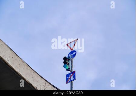 Vue de dessous d'un feu vert et de divers panneaux de signalisation à une intersection sur un pont à Berlin, Allemagne. Banque D'Images