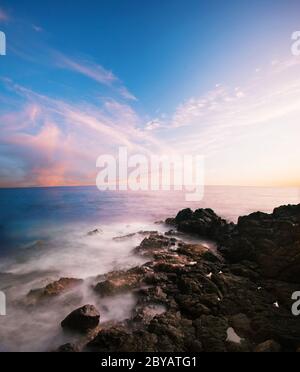 Coucher de soleil sur la plage de pierres volcaniques. Hawaï Banque D'Images