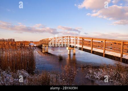 pont en bois sur la rivière au lever du soleil Banque D'Images