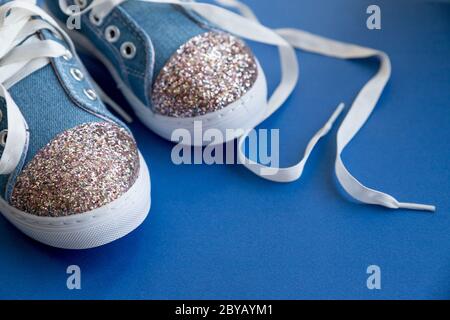 Chaussures en denim pour enfants avec lacets sur fond bleu.mode pour enfants.enfants Chaussures en dentelle textile sur fond de peau rouée.mode fille pour enfant féminin Banque D'Images