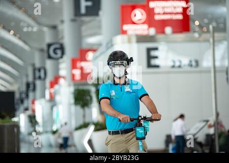 Istanbul, Turquie. 9 juin 2020. Un employé portant un casque à thermoexposition VF surveille les gens à l'aéroport d'Istanbul, en Turquie, le 9 juin 2020. La technologie et l'innovation seront les principales précautions prises par le plus grand aéroport turc d'Istanbul contre le COVID-19 dans l'ère post-pandémique, selon la direction de l'aéroport. La direction a présenté mardi les préparatifs et les mesures finales prises contre le coronavirus, tandis que les compagnies aériennes turques se préparent à reprendre leurs opérations internationales le lendemain. Crédit: Yasin Akgul/Xinhua/Alay Live News Banque D'Images