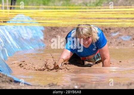 Poley Mountain, Nouveau-Brunswick, Canada - 10 juin 2017 : participation à la collecte de fonds annuelle « la course de boue au cœur ». Ramper dans la boue et l'eau. Banque D'Images