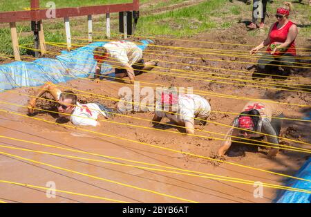 Poley Mountain, Nouveau-Brunswick, Canada - 10 juin 2017 : participation à la collecte de fonds annuelle « la course de boue au cœur ». Ramper dans la boue et l'eau. Banque D'Images