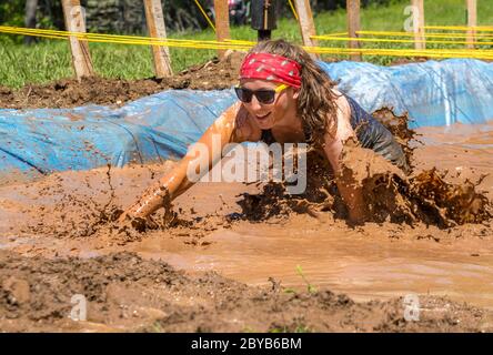 Poley Mountain, Nouveau-Brunswick, Canada - 10 juin 2017 : participation à la collecte de fonds annuelle « la course de boue au cœur ». Ramper dans la boue et l'eau. Banque D'Images