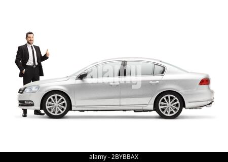 Homme d'affaires debout à côté d'une voiture argentée et montrant les pouces isolés sur fond blanc Banque D'Images