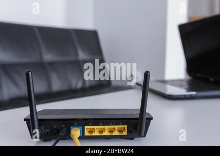 Routeur wi-fi moderne sur table lumineuse dans la chambre Banque D'Images