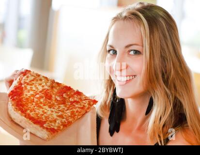 Portrait d'une jeune femme souriante avec pizza Banque D'Images