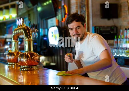 Jeune Bartender nettoyage du bar. Banque D'Images