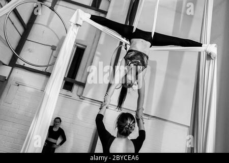 Les danseurs aériens colombiens jouent un duo sur des silks aériens pendant une séance d'entraînement dans une salle de gym à Medellín, Colombie- Banque D'Images