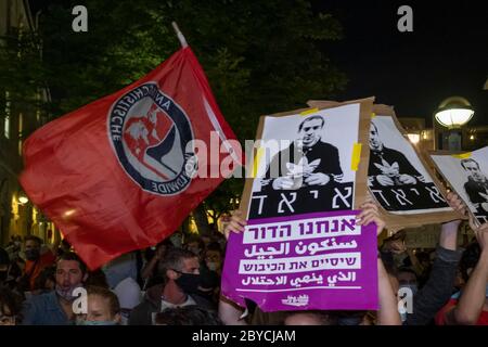 Jérusalem, Israël. 9 juin 2020. Des militants de gauche agitent le drapeau du mouvement politique antifasciste Antifa et des pancartes portant l’image d’Iyad Hallak lors d’une manifestation à Jérusalem le 9 juin 2020 contre le meurtre d’Iyad Hallak, Un palestinien handicapé abattu par la police israélienne ainsi que du meurtre de George Floyd, afro-américain non armé. Crédit : Eddie Gerald/Alamy Live News Banque D'Images