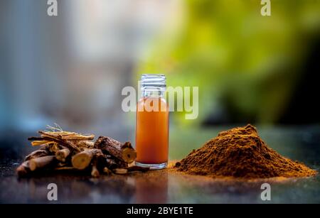 Prise de Rheum emodi ou Revand Chini avec son essence de racine extraite et sa poudre brute sur une surface noire brillante. Banque D'Images