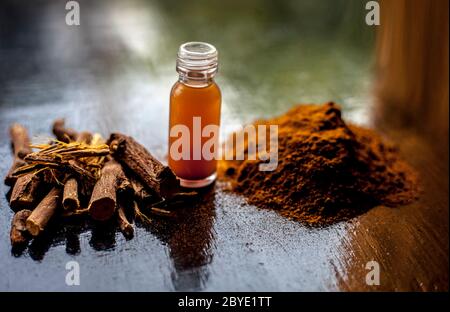 Prise de Rheum emodi ou Revand Chini avec son essence de racine extraite et sa poudre brute sur une surface noire brillante. Banque D'Images