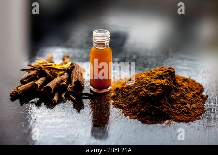 Prise de Rheum emodi ou Revand Chini avec son essence de racine extraite et sa poudre brute sur une surface noire brillante. Banque D'Images