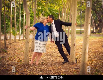 Couple charmant embrassant et tenant les mains marchant dans le bois Banque D'Images