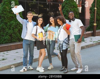 Bonnes années d'études. Portrait des étudiants internationaux heureux se posant ensemble à l'extérieur Banque D'Images