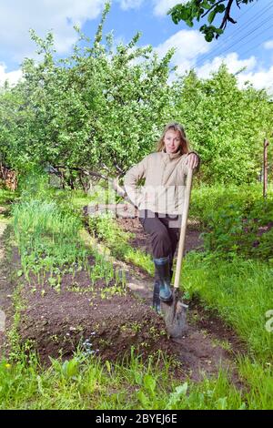 femme creuse un lit de jardin avec les premiers pousses Banque D'Images