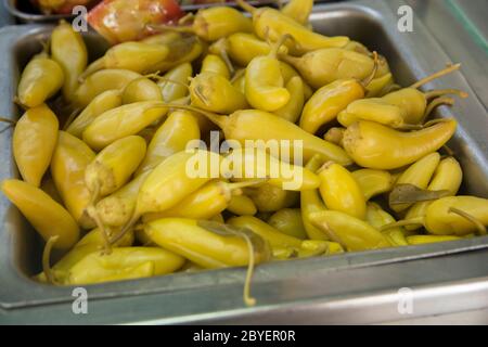 Gros plan des poivrons de Chili jaunes marinés dans un récipient en métal Banque D'Images