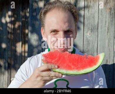 l'homme heureux avec un morceau de melon d'eau Banque D'Images