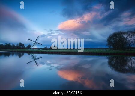 coucher de soleil spectaculaire sur le moulin à vent au bord de la rivière Banque D'Images