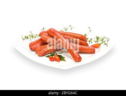 Saucisses de poulet croustillant grillées avec des piments et du thym sur une assiette blanche. Viande de barbecue isolée sur fond blanc Banque D'Images